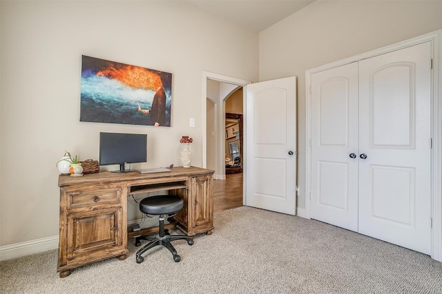 carpeted office space with arched walkways and baseboards