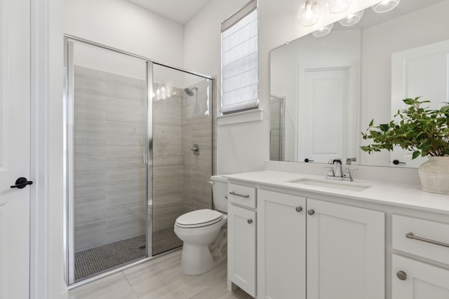 full bath featuring toilet, a shower stall, and vanity