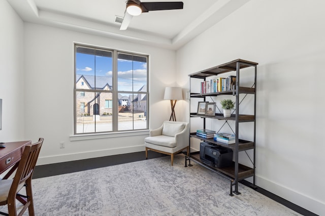 office space with ceiling fan, baseboards, a raised ceiling, and wood finished floors