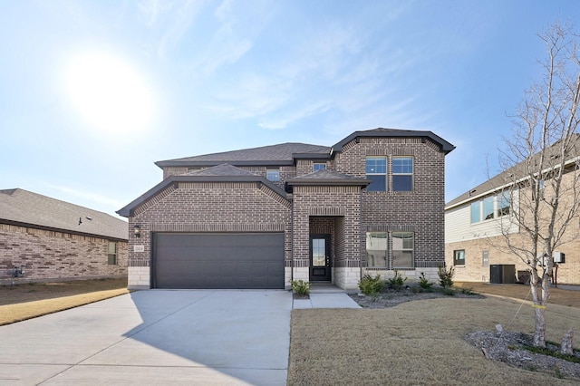 view of front of property featuring central AC unit, a garage, brick siding, a shingled roof, and driveway