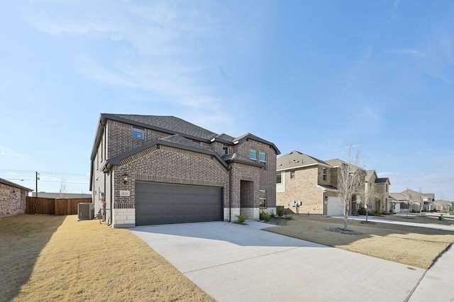 view of front of house featuring a garage, concrete driveway, fence, cooling unit, and brick siding