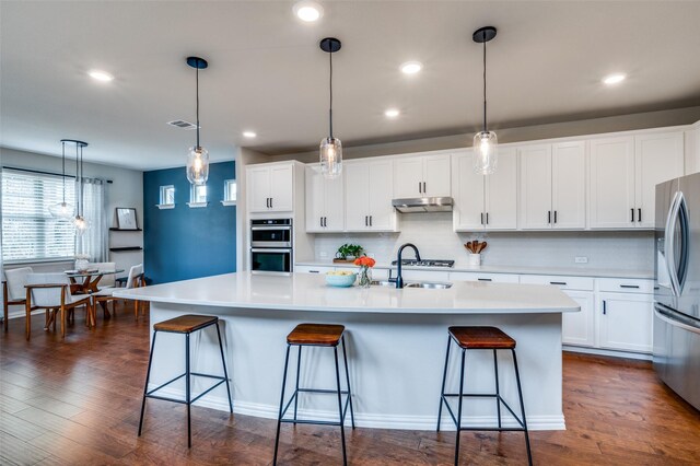 2064 Olivereta Dr, Little Elm, TX 75068 - kitchen with stainless steel appliances, under cabinet range hood, backsplash, recessed lighting, and light countertops