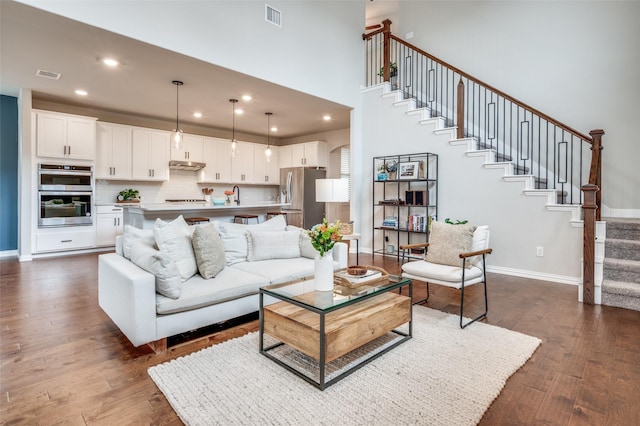 2064 Olivereta Dr, Little Elm, TX 75068 - living area featuring dark wood-type flooring, stairway, recessed lighting, baseboards, and a towering ceiling