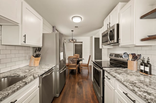 kitchen featuring tasteful backsplash, white cabinets, dark wood-style floors, appliances with stainless steel finishes, and open shelves