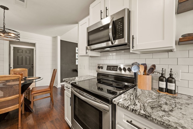 kitchen with light stone countertops, white cabinetry, appliances with stainless steel finishes, and decorative backsplash