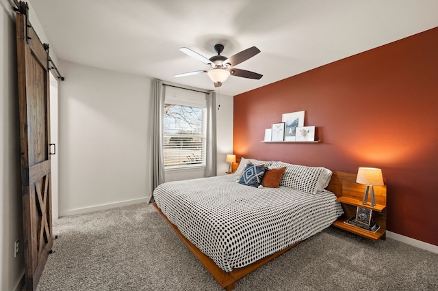 bedroom featuring carpet floors, a barn door, baseboards, and a ceiling fan