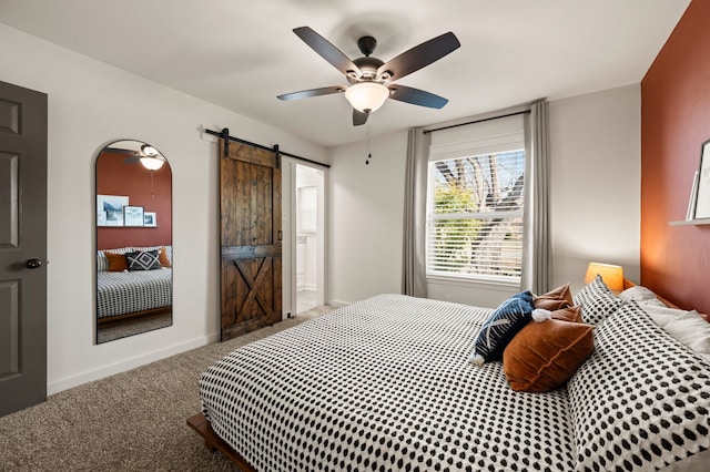 bedroom with carpet floors, ceiling fan, baseboards, and a barn door