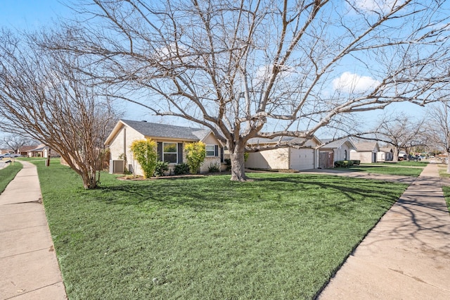 ranch-style home featuring a garage, driveway, and a front lawn