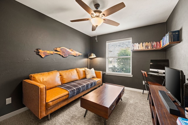 interior space featuring a ceiling fan, carpet flooring, a textured wall, and baseboards