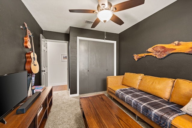 carpeted living area with ceiling fan and visible vents