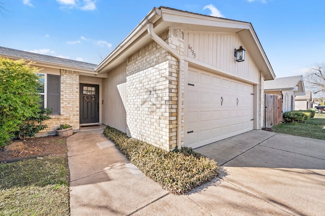 exterior space with a garage, concrete driveway, and brick siding