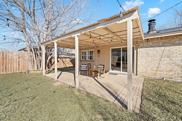 rear view of house with a yard, a patio area, fence, and brick siding