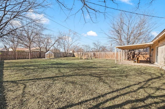 view of yard with a fenced backyard, an outdoor structure, and a patio