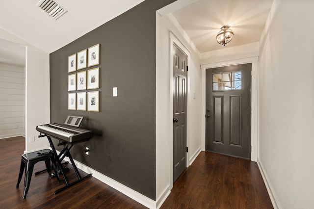 foyer entrance with baseboards, visible vents, and wood finished floors