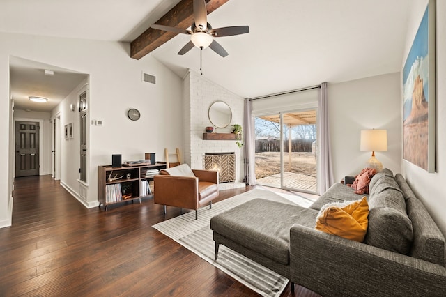 living area with vaulted ceiling with beams, a fireplace, visible vents, and wood finished floors