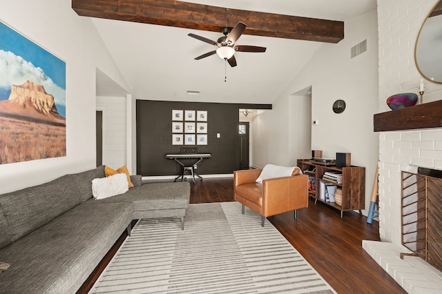 living room with visible vents, a fireplace, beamed ceiling, and wood finished floors