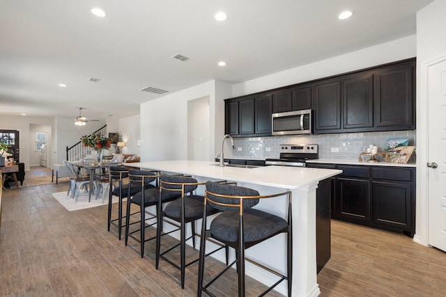 kitchen featuring stainless steel appliances, light wood finished floors, and visible vents