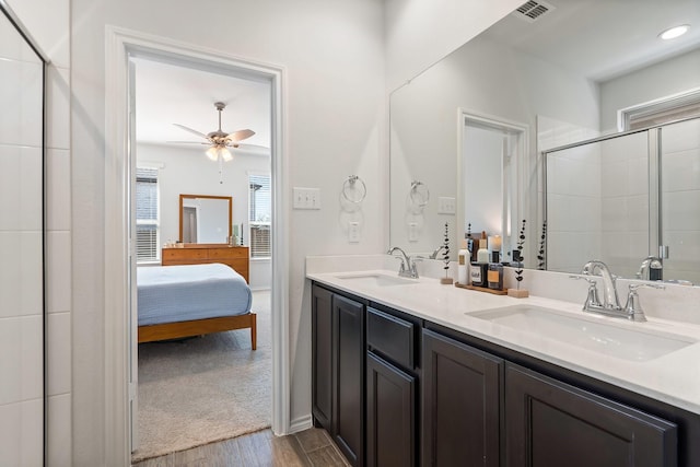 ensuite bathroom with double vanity, connected bathroom, visible vents, and a sink