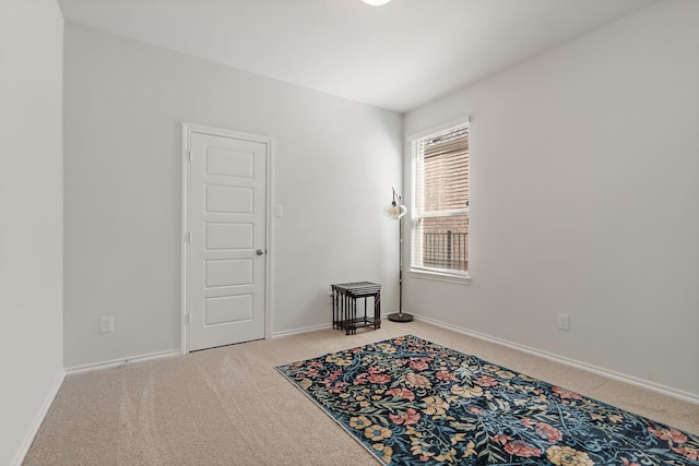 carpeted spare room featuring baseboards