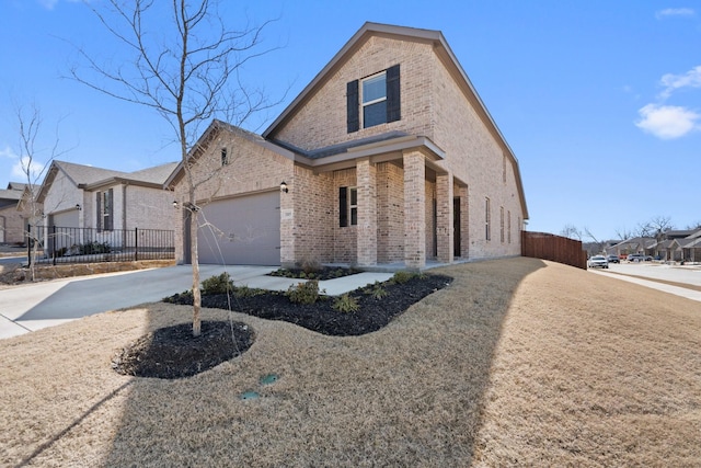 traditional-style home with brick siding, concrete driveway, fence, a garage, and a residential view