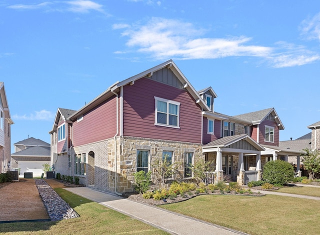 view of front facade with central AC unit, stone siding, a front lawn, a porch, and board and batten siding