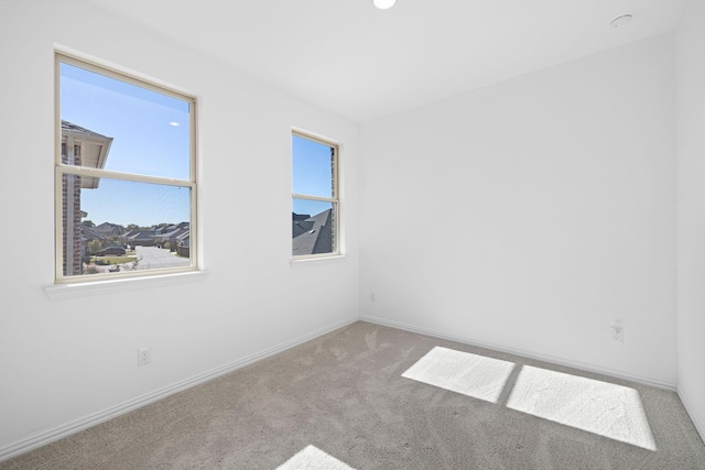 carpeted empty room featuring baseboards