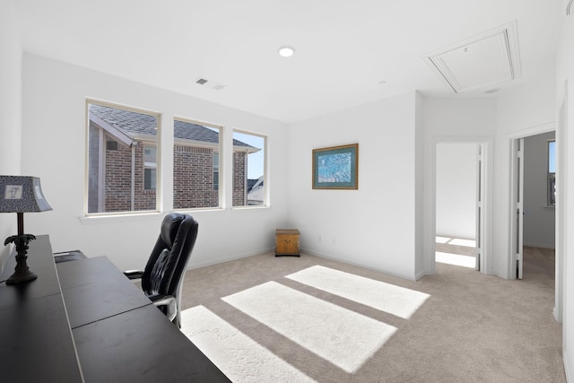 office space with attic access, visible vents, baseboards, and light colored carpet