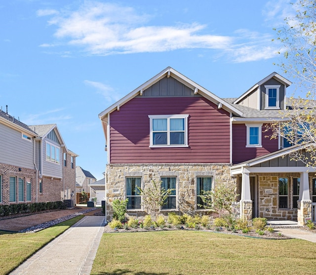 view of front of property with stone siding, a front lawn, and board and batten siding