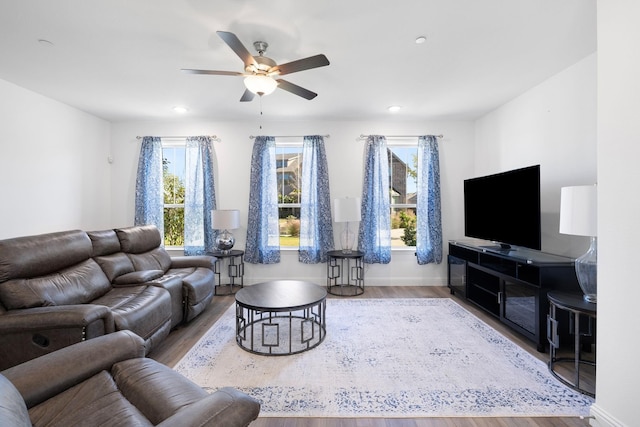 living room featuring a ceiling fan, recessed lighting, baseboards, and wood finished floors