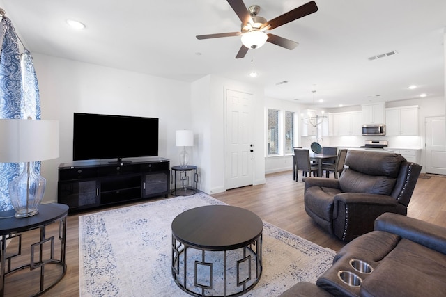 living area with light wood finished floors, baseboards, visible vents, and recessed lighting