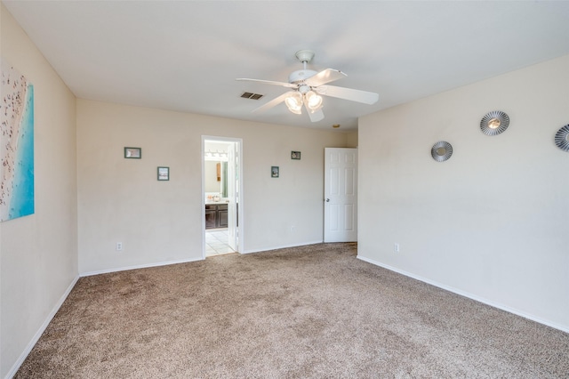 carpeted empty room featuring baseboards, visible vents, and a ceiling fan