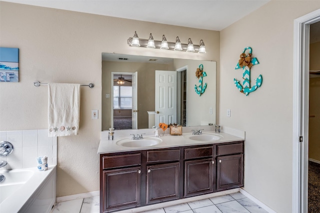 bathroom featuring double vanity, a sink, baseboards, and a bath