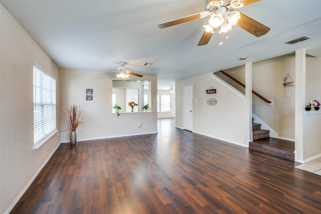 unfurnished living room with stairway, wood finished floors, visible vents, and baseboards