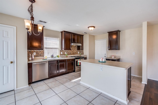 kitchen with a sink, dark brown cabinets, stainless steel appliances, and light countertops