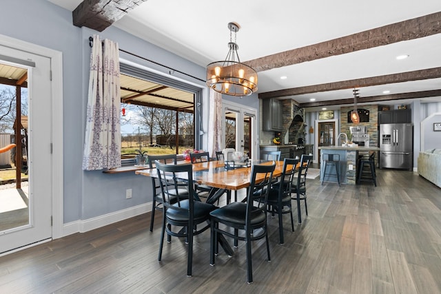 dining space with dark wood-type flooring, a healthy amount of sunlight, and beamed ceiling