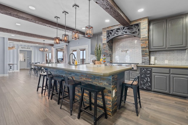 kitchen with decorative backsplash, wood finished floors, and gray cabinetry