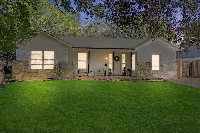 ranch-style house featuring stone siding, a front lawn, and covered porch