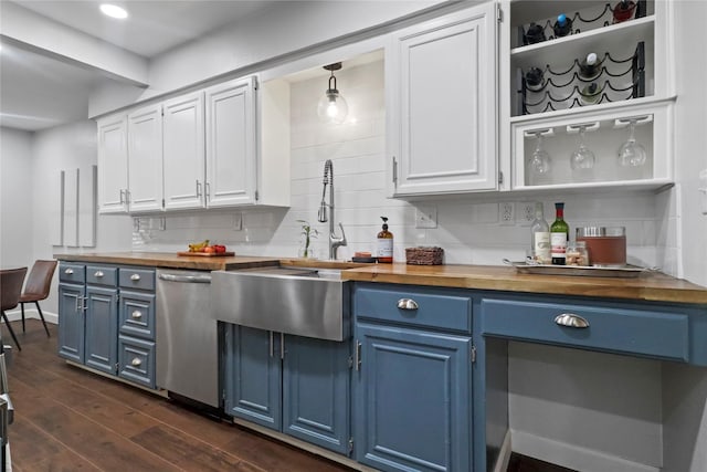 kitchen with butcher block countertops, stainless steel dishwasher, blue cabinetry, and tasteful backsplash