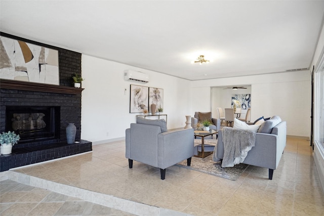 living area with a wall unit AC, light tile patterned floors, visible vents, a brick fireplace, and baseboards