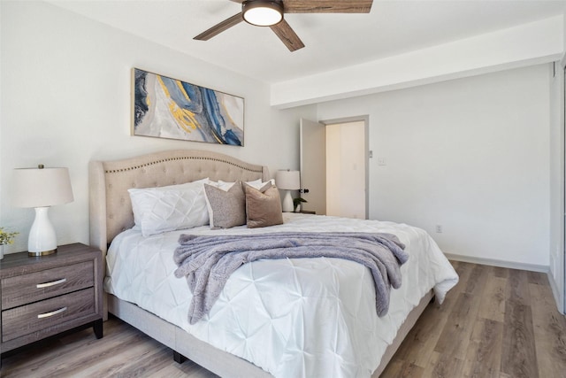 bedroom with a ceiling fan, baseboards, and wood finished floors