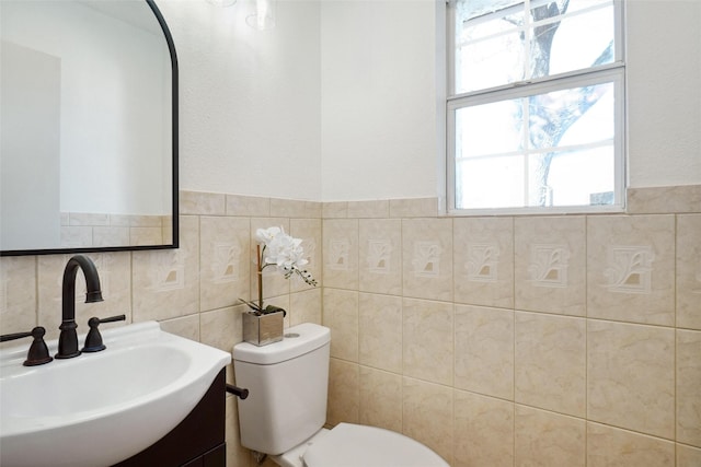 bathroom with tile walls, vanity, and toilet