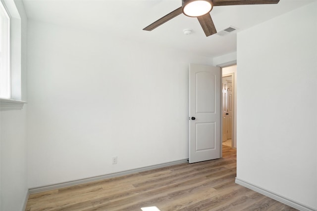 unfurnished room with light wood-style flooring, visible vents, ceiling fan, and baseboards