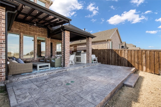 view of patio featuring exterior kitchen, a fenced backyard, and ceiling fan