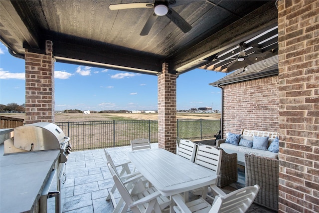 view of patio featuring ceiling fan, outdoor dining area, an outdoor kitchen, fence, and an outdoor living space