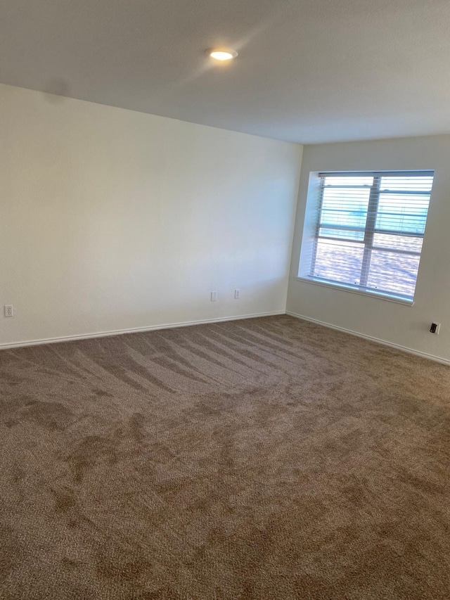 spare room with carpet flooring and baseboards