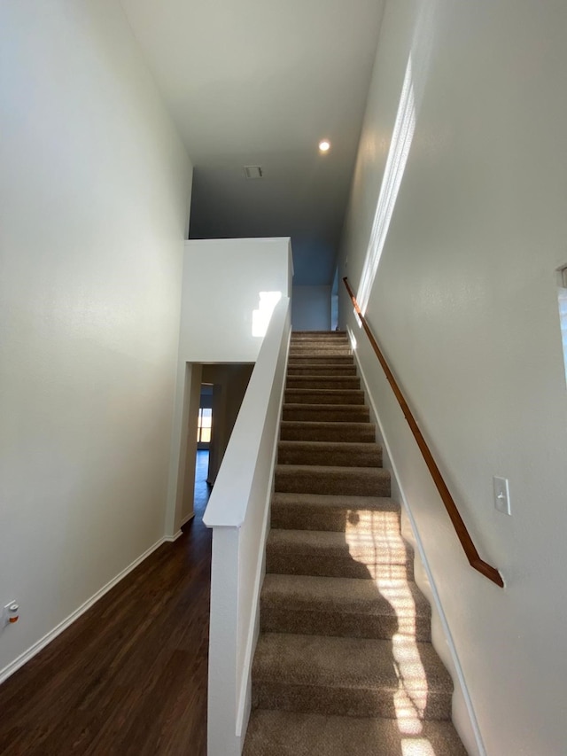 staircase with baseboards and wood finished floors