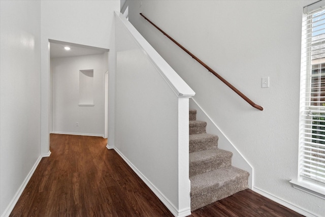 staircase with baseboards and wood finished floors
