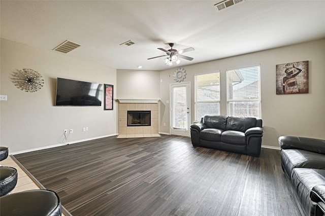 living room featuring a wealth of natural light, dark wood-type flooring, and visible vents