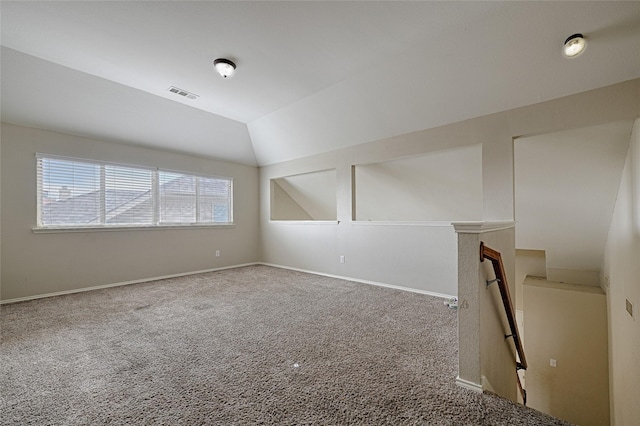 carpeted empty room featuring lofted ceiling, visible vents, and baseboards