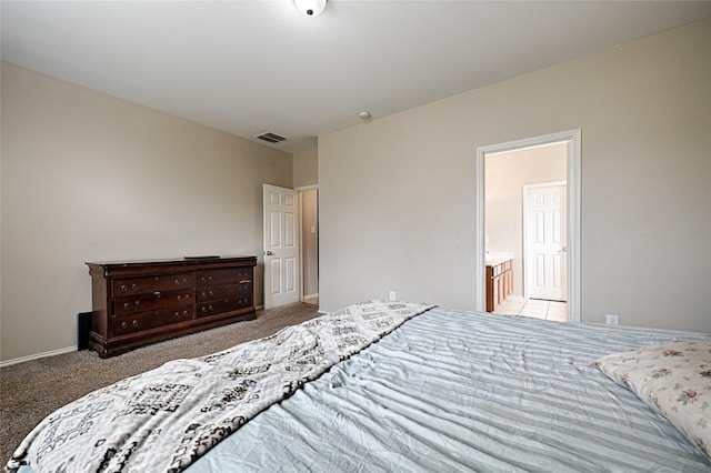 bedroom featuring carpet floors, ensuite bath, visible vents, and baseboards